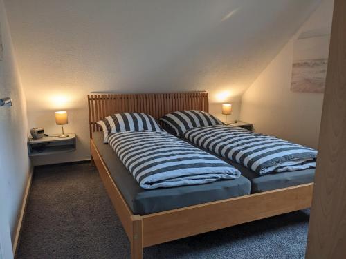 two beds with striped pillows in a room at Ferienwohnung Ankerplatz in Niebüll