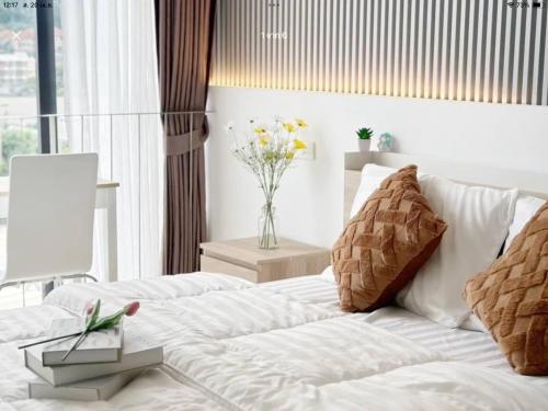 a bedroom with a white couch and a vase of flowers at เดอะสแควร์ คอนโดมิเนียม in Ban Phlu Yai