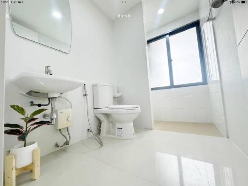 a white bathroom with a sink and a toilet at เดอะสแควร์ คอนโดมิเนียม in Ban Phlu Yai