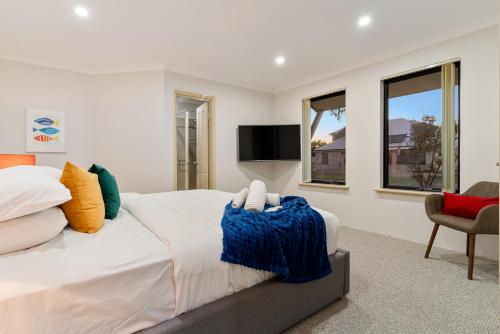 a bedroom with a large bed and a tv at Sandy Retreat Your Perfect Beach Getaway in Silversands in Mandurah