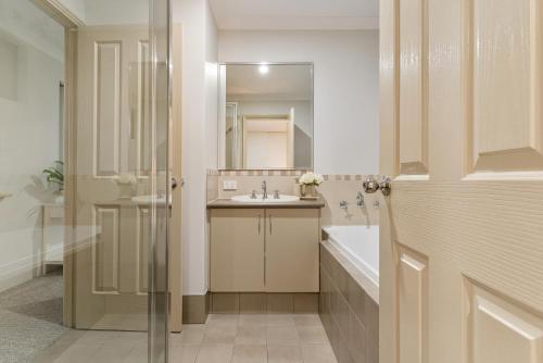 a bathroom with a sink and a mirror at Sandy Retreat Your Perfect Beach Getaway in Silversands in Mandurah
