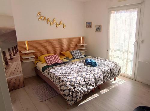 une chambre avec un lit avec des oreillers dessus dans l'établissement À 8 min à pieds de la plage, du centre ville et du Brittany Ferries, à Ouistreham