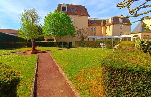 une grande maison avec une cour dotée d'une pelouse dans l'établissement À 8 min à pieds de la plage, du centre ville et du Brittany Ferries, à Ouistreham