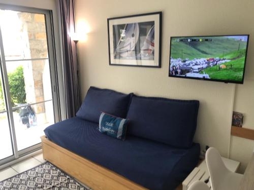 une chambre avec un lit avec une télévision au mur dans l'établissement Appartement bord de mer, à Arzon