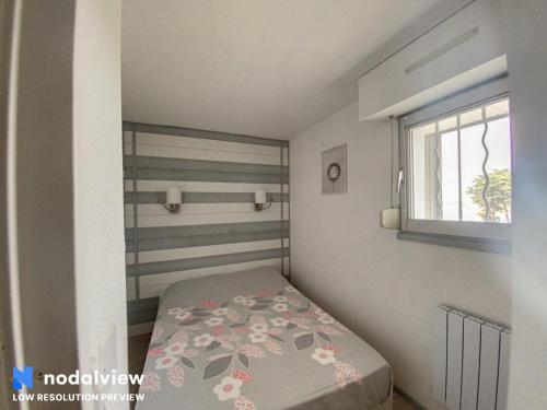 une petite chambre avec un lit et une fenêtre dans l'établissement Couleur Ocean, à Quiberon