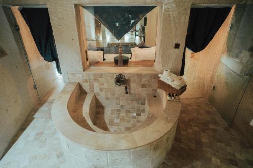 a large bathroom with a stone tub with a mirror at Hu of Cappadocia - Special Class in Uchisar