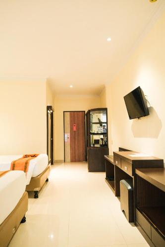a hotel room with two beds and a flat screen tv at Khas Parapat in Parapat
