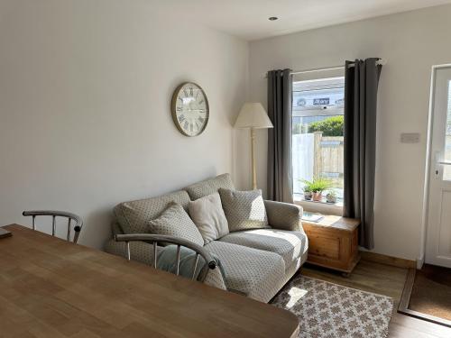 a living room with a couch and a clock on the wall at Immaculate 2-Bed Lodge in Hayle in Hayle