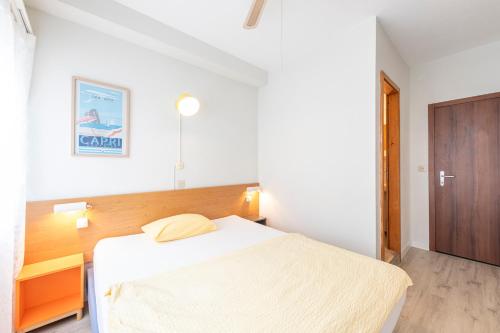 a bedroom with a white bed and a wooden headboard at Hotel Atlantico self check-in in Lugano