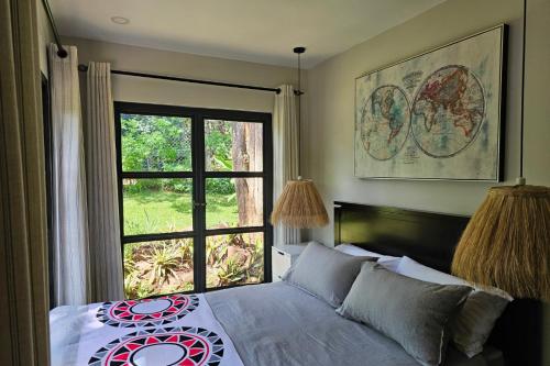 a bedroom with a bed with a large window at Pumbaa Farmhouse + Cottages in Nairobi