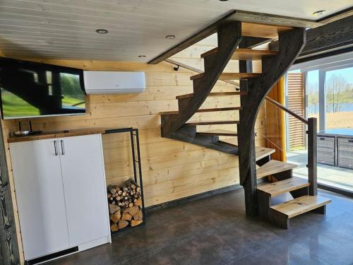 a room with a wooden wall with a staircase and a refrigerator at Domek nad jeziorem in Krasnopol