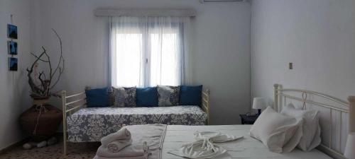 House On The Wave في ماراثوكامبوس: غرفة نوم مع سرير ووسائد زرقاء ونافذة