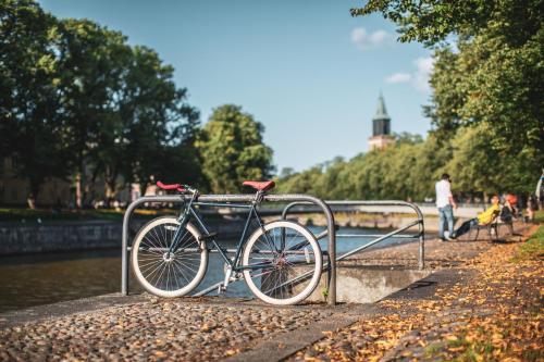 Original Sokos Hotel Wiklund في توركو: دراجة مربوطة بسكة حديدية بجوار نهر