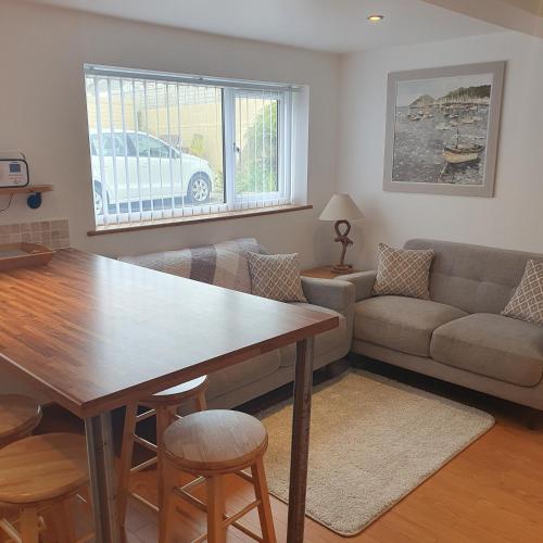 a living room with a table and a couch at Chynoweth Mews in Newquay