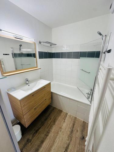 une salle de bain avec un lavabo, une baignoire et un miroir dans l'établissement Appartement 6 personnes au pied des pistes à la Foux d'Allos, à Allos