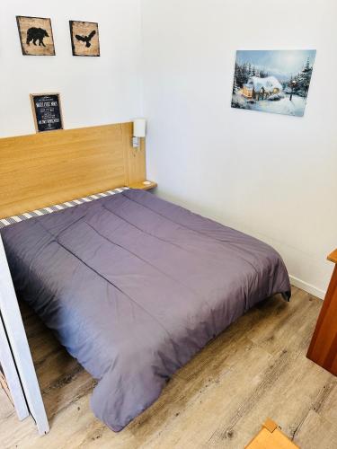 - un lit dans une chambre avec une tête de lit en bois dans l'établissement Appartement 6 personnes au pied des pistes à la Foux d'Allos, à Allos