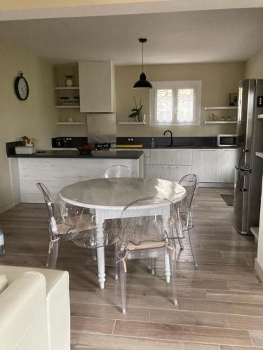 une cuisine avec une table en verre et des chaises dans l'établissement Maison de village, à Valle-di-Rostino