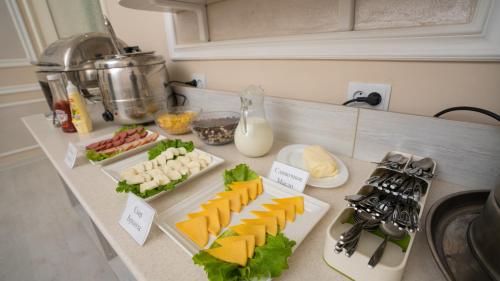 a counter top with cheese and other food on it at Osiyo Plaza Hotel in Samarkand