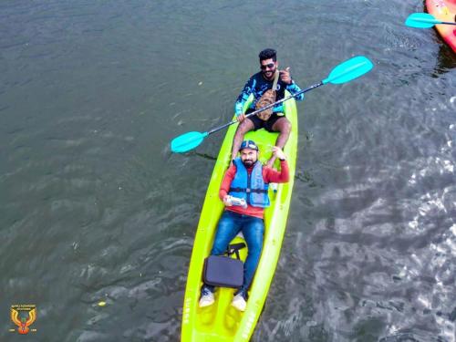 two men in a yellow kayak on the water at Lotus cool hotel and restaurant in Ibbagomuwa