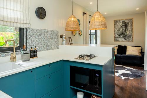 a kitchen with blue cabinets and a stove top oven at Pumbaa Farmhouse + Cottages in Nairobi