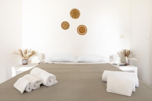 een witte slaapkamer met een bed met handdoeken erop bij Borgo Borgia - Casa del Beccaio in Giurdignano