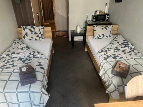 um quarto com 2 camas e uma mesa com um micro-ondas em Šiauliu apartamentai em Siauliai