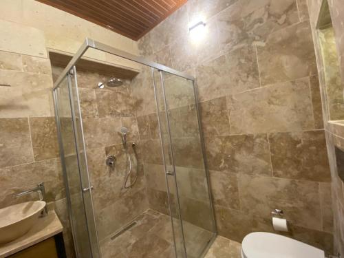 a bathroom with a shower with a toilet and a sink at Cappadocia Fairy Tale Suites in Goreme