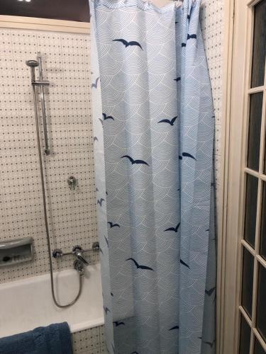 a bathroom with a shower curtain with birds on it at Casa di Charme lungo Po in Turin