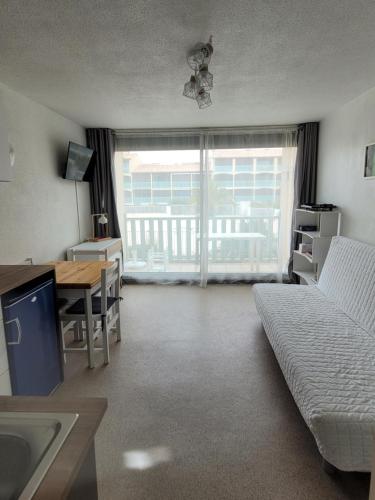 un salon avec un canapé, une table et un bureau dans l'établissement Studio Gruissan, à Gruissan