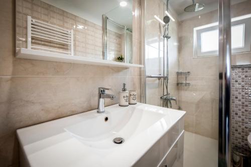 a bathroom with a white sink and a shower at Apartman Oly in Rovinj