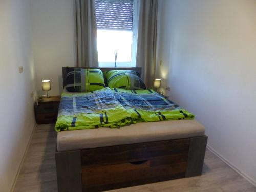 1 dormitorio con 1 cama con edredón verde y ventana en Ferienwohnung in Hof Saale en Hof