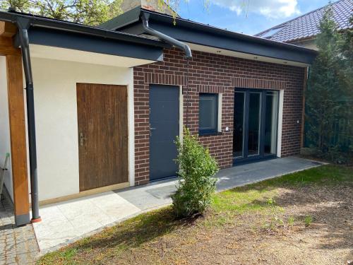 a brick house with a brown door and a driveway at +Authentic+ in Mariánské Lázně