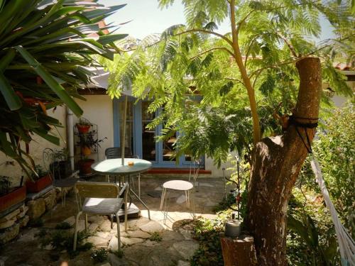 a patio with a table and chairs and a tree at La campagne dans la ville in Narbonne