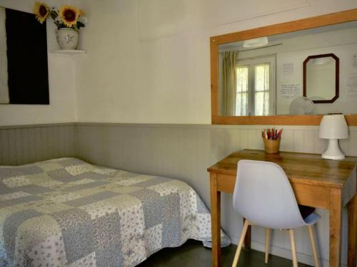 a bedroom with a bed and a desk with a mirror at La campagne dans la ville in Narbonne