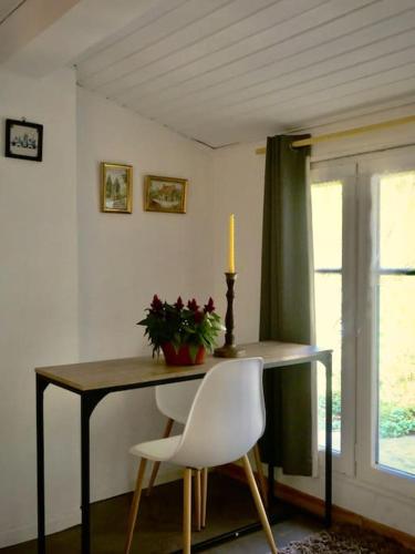 une table de salle à manger avec une bougie et une chaise blanche dans l'établissement La campagne dans la ville, à Narbonne