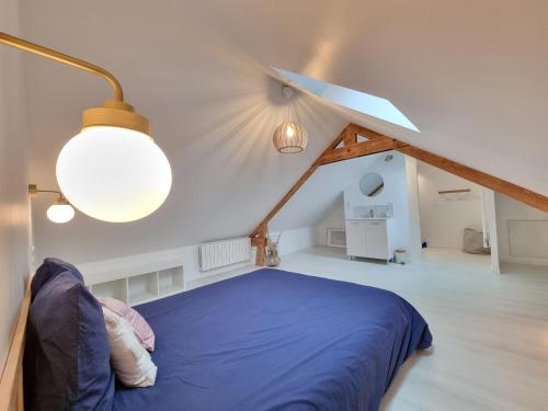 - une chambre mansardée avec un lit bleu dans l'établissement BRISE MARINE DU PRIEURÉ spacieux lumineux à 2 min de la plage, à Dinard