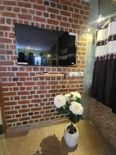 a brick fireplace with a vase with flowers in it at Paradise Forest Resort in Puducherry