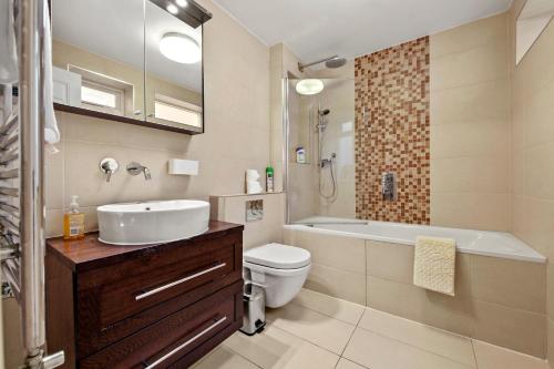 a bathroom with a sink and a tub and a toilet at Stylish Apartment in Euston and near Camden with Private Roof Terrace in London