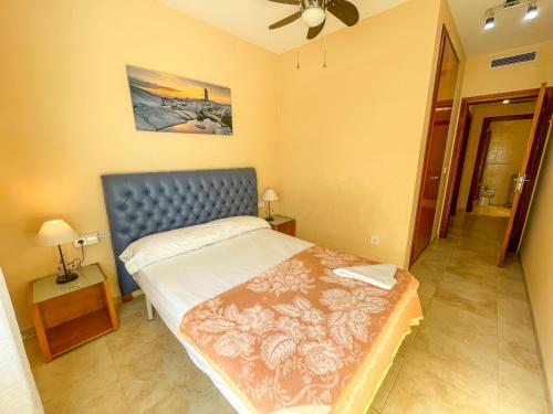 1 dormitorio con 1 cama con cabecero azul en Apartament Peñíscola Centro Llandels 3000, en Peñíscola