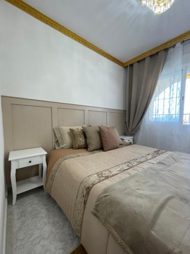 a bedroom with a large bed and a chandelier at Casa Amarela Guesthouse, Algorfa in Algorfa