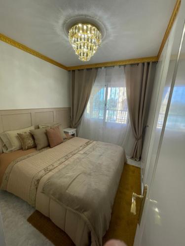 a bedroom with a large bed and a chandelier at Casa Amarela Guesthouse, Algorfa in Algorfa