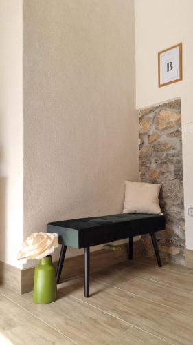 - un banc dans le salon avec un tabouret vert dans l'établissement Comfortable Apartment & Studio in Village Centre, à Komen