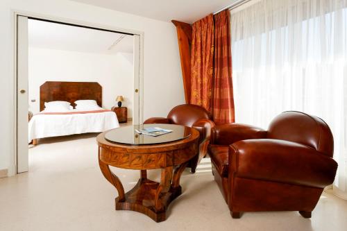 a bedroom with a table and two chairs and a bed at Logis L'Auberge - Maison Glenn Anna in Sainte Anne d'Auray