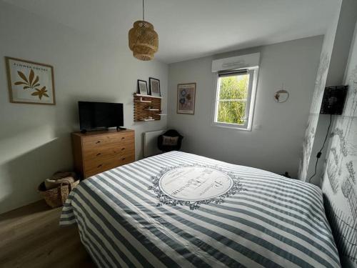 une chambre avec un lit avec une couette bleue et blanche dans l'établissement T2 avec jardinet parking la genette, à La Rochelle