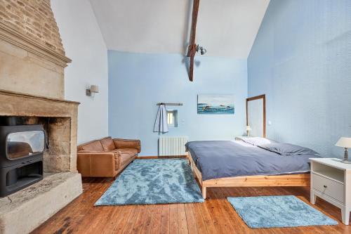une chambre avec un lit et une cheminée dans l'établissement Augustine Beach - Maison à 700 m de la plage, à Courseulles-sur-Mer