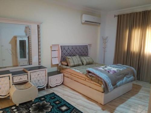 um quarto com uma cama grande e um espelho em فيلا مفروشة بالكامل em Naj‘ al Aḩwāl