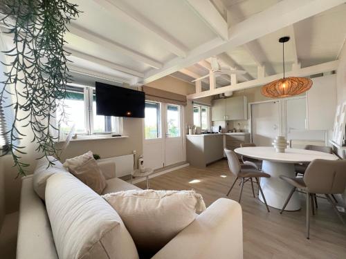 a living room with a couch and a table at New- The Cabana- With Sauna and Hot Tub, on a lake near Amsterdam in Vinkeveen