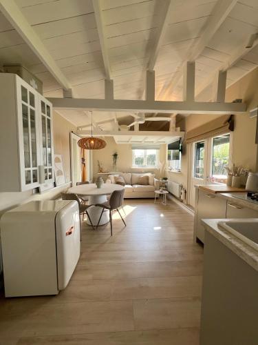a kitchen and living room with a table and a couch at New- The Cabana- With Sauna and Hot Tub, on a lake near Amsterdam in Vinkeveen