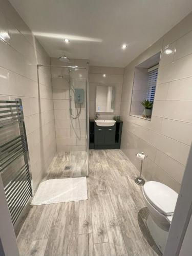 a bathroom with a shower and a toilet and a sink at Pheasants Crossing - luxurious and cozy cottage in peaceful rural location in Almondbury