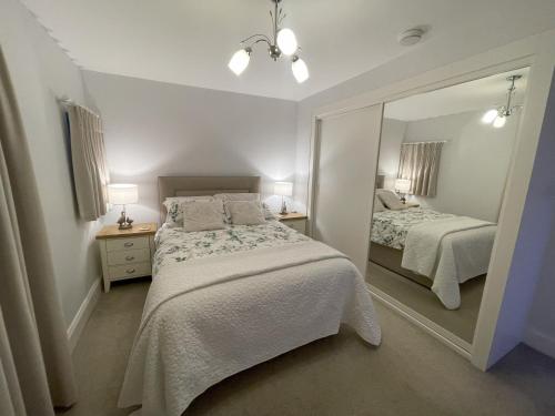 a bedroom with two beds and a large mirror at Pheasants Crossing - luxurious and cozy cottage in peaceful rural location in Almondbury